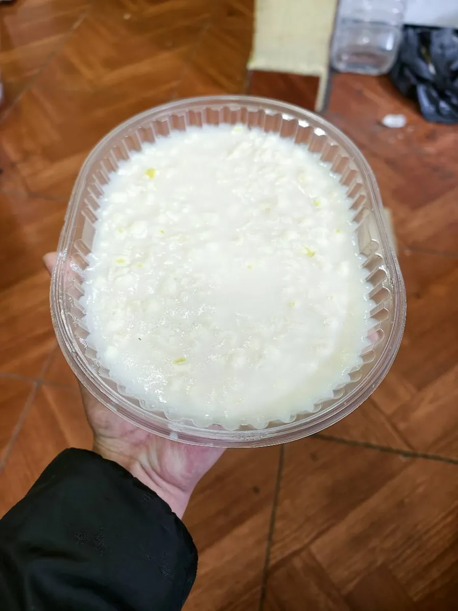 Foto real del envase de tujure sostenido en una mano